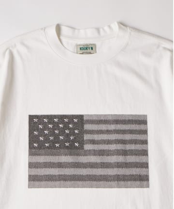 WHO’S WHO gallery(フーズフーギャラリー) 【UNISEX】KOOKY'N スタースタッズフラッググラフィックTEE