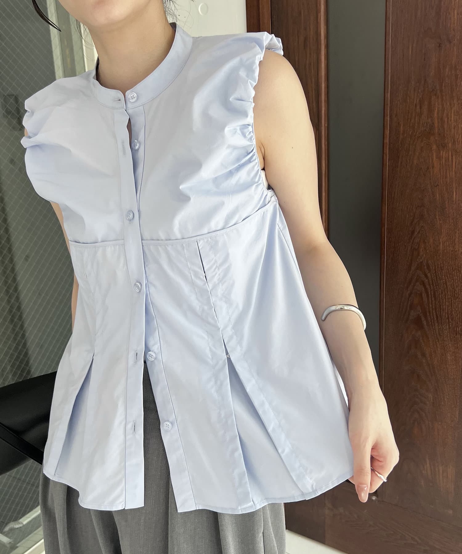 胸下のコルセットのような切替が女性らしいノースリシャツ商品ポイント・パフっとした袖口がポイントのノースリシャツ・胸下のダーツにホックが付いており、開けて着ると広がりのあるシルエットに・ヒップにかかる着