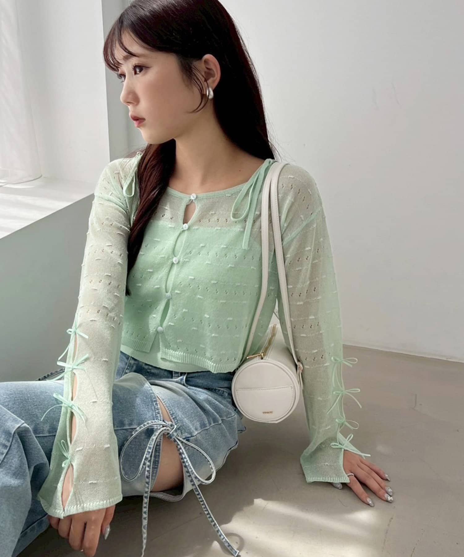 ~NICECLAUP 2025 Summer Collection~シアーニットと、同素材のニットキャミがセットになったアンサンブルアイテム袖口にはさりげなくリボンデザインを施し、フェミニンなアクセン