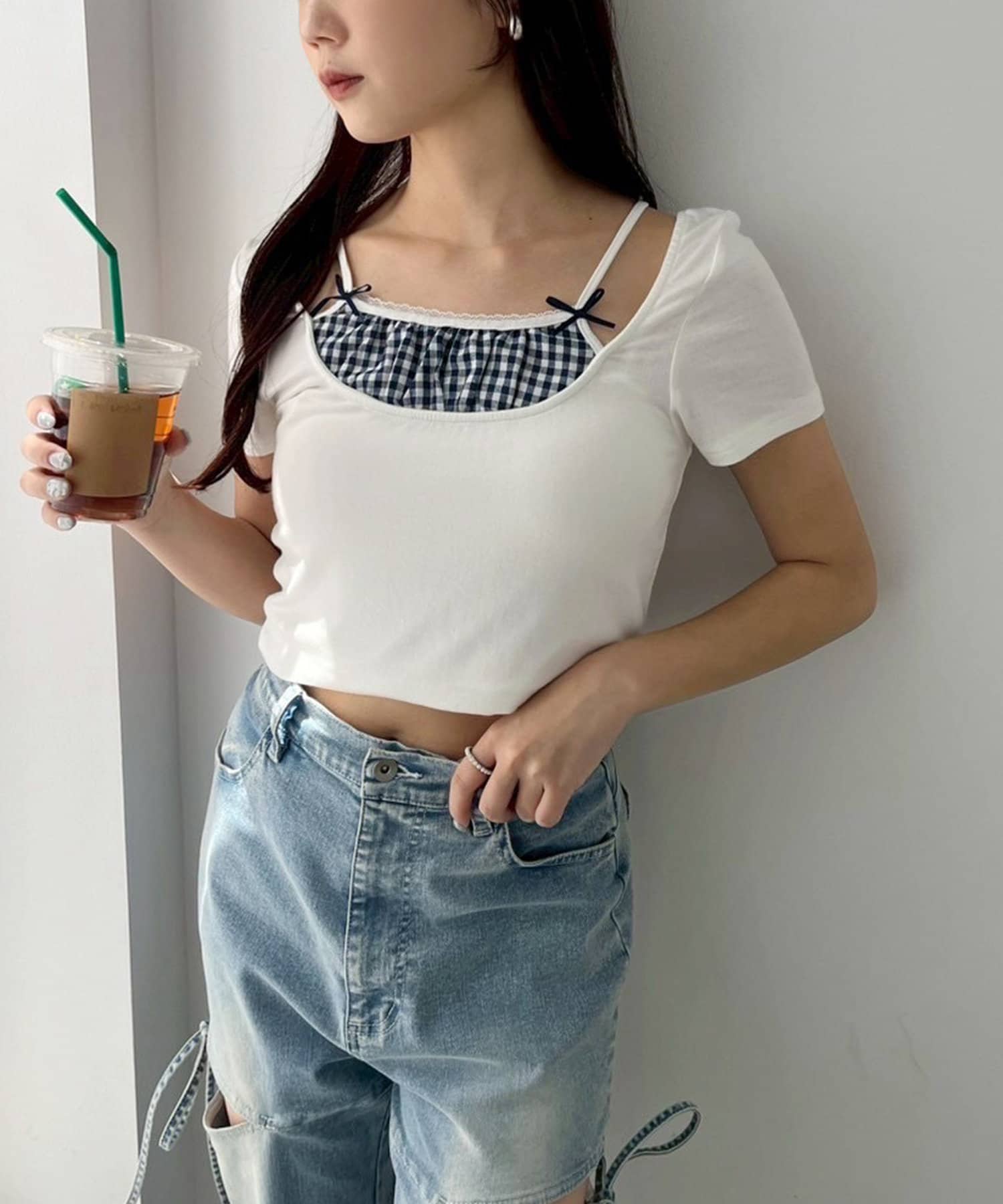 ~NICECLAUP 2025 Early Summer Collection~チェックインナーをレイヤードしているようなデザインが特徴の、ガーリーなニット。胸元にはリボンを施し、コーディネートのアク