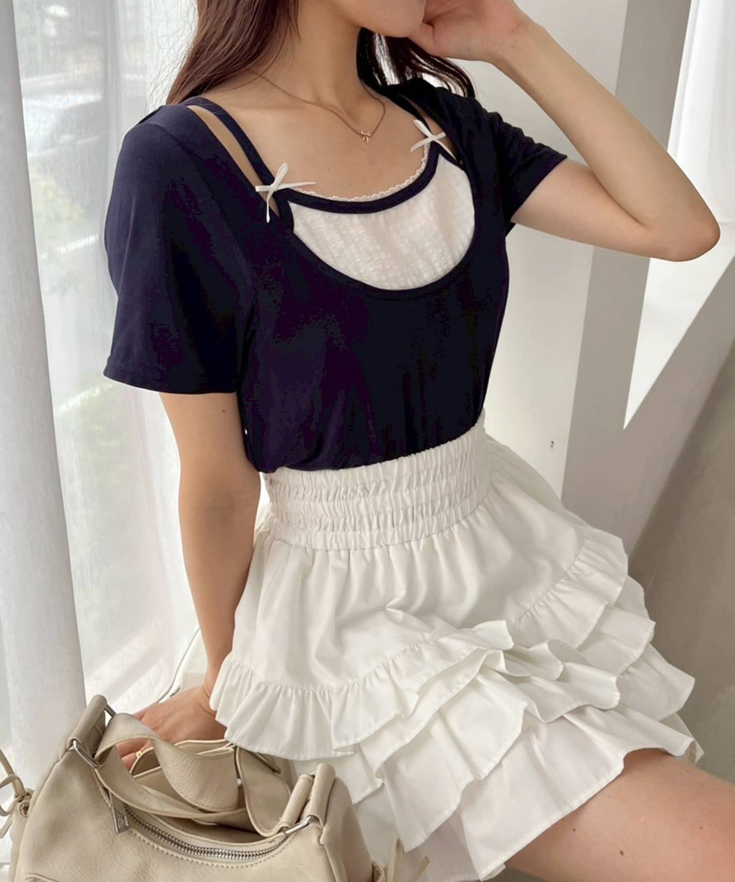 ~NICECLAUP 2025 Early Summer Collection~チェックインナーをレイヤードしているようなデザインが特徴の、ガーリーなニット。胸元にはリボンを施し、コーディネートのアク