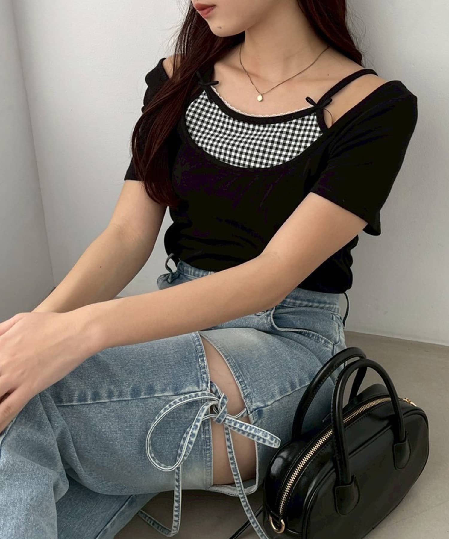 ~NICECLAUP 2025 Early Summer Collection~チェックインナーをレイヤードしているようなデザインが特徴の、ガーリーなニット。胸元にはリボンを施し、コーディネートのアク