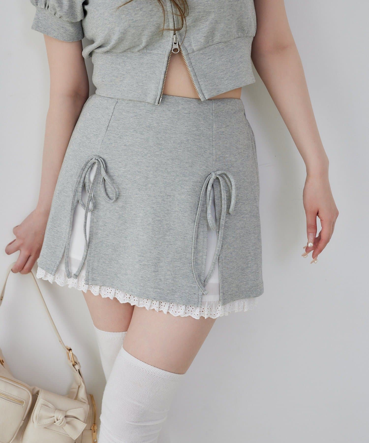 ~NICECLAUP 2025SS Summer Collection~程よくフィットするシルエットに、裾のレースデザインとリボンがフェミニンなアクセントをプラス。カット素材ならではの柔らかい着心地で