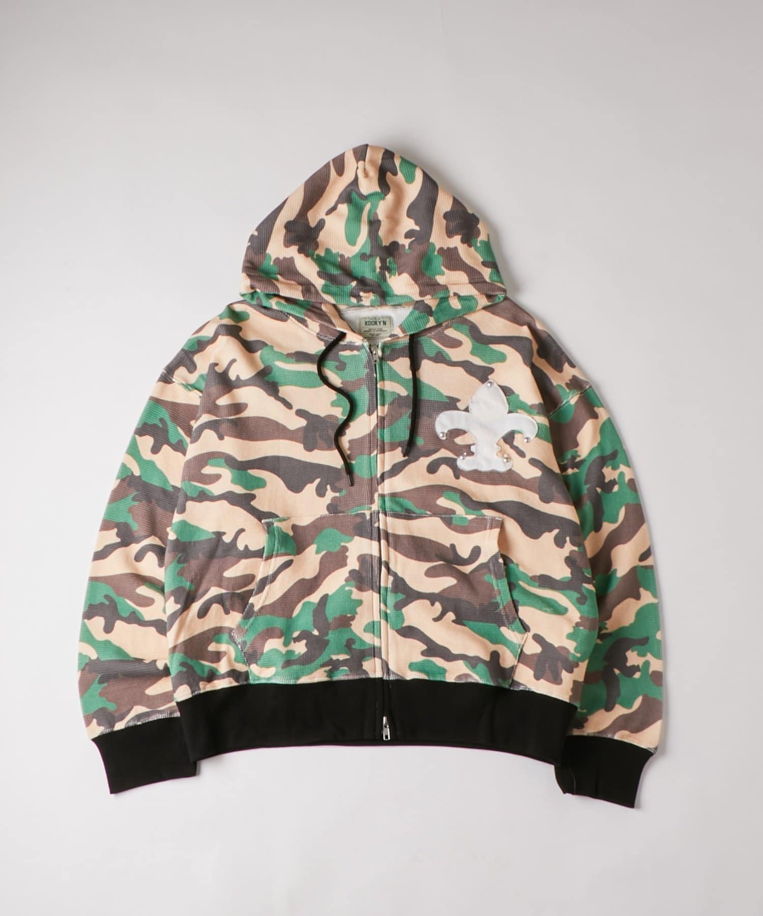 WHO’S WHO gallery(フーズフーギャラリー) 【UNISEX】KOOKY'Nカモ柄ワッフルユリ紋章スタッズジップパーカー