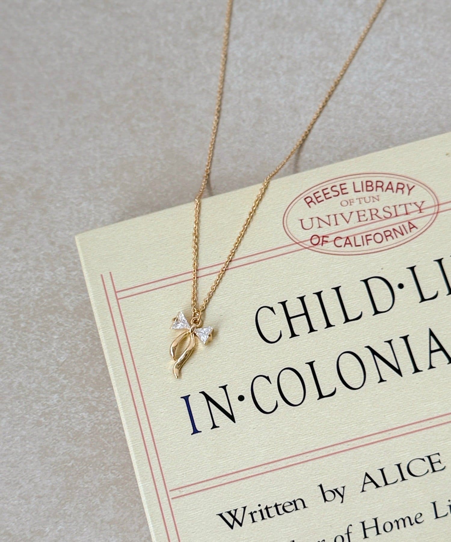 3COINS(スリーコインズ) キラキラリボンショートネックレス