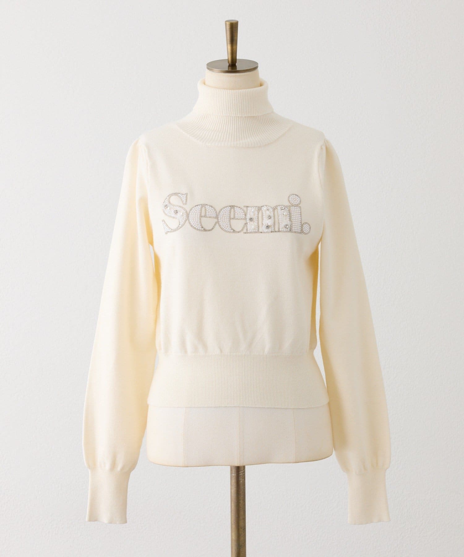Seemi.by NICE CLAUP(シーミーバイナイスクラップ) ハイネックビジューロゴニット