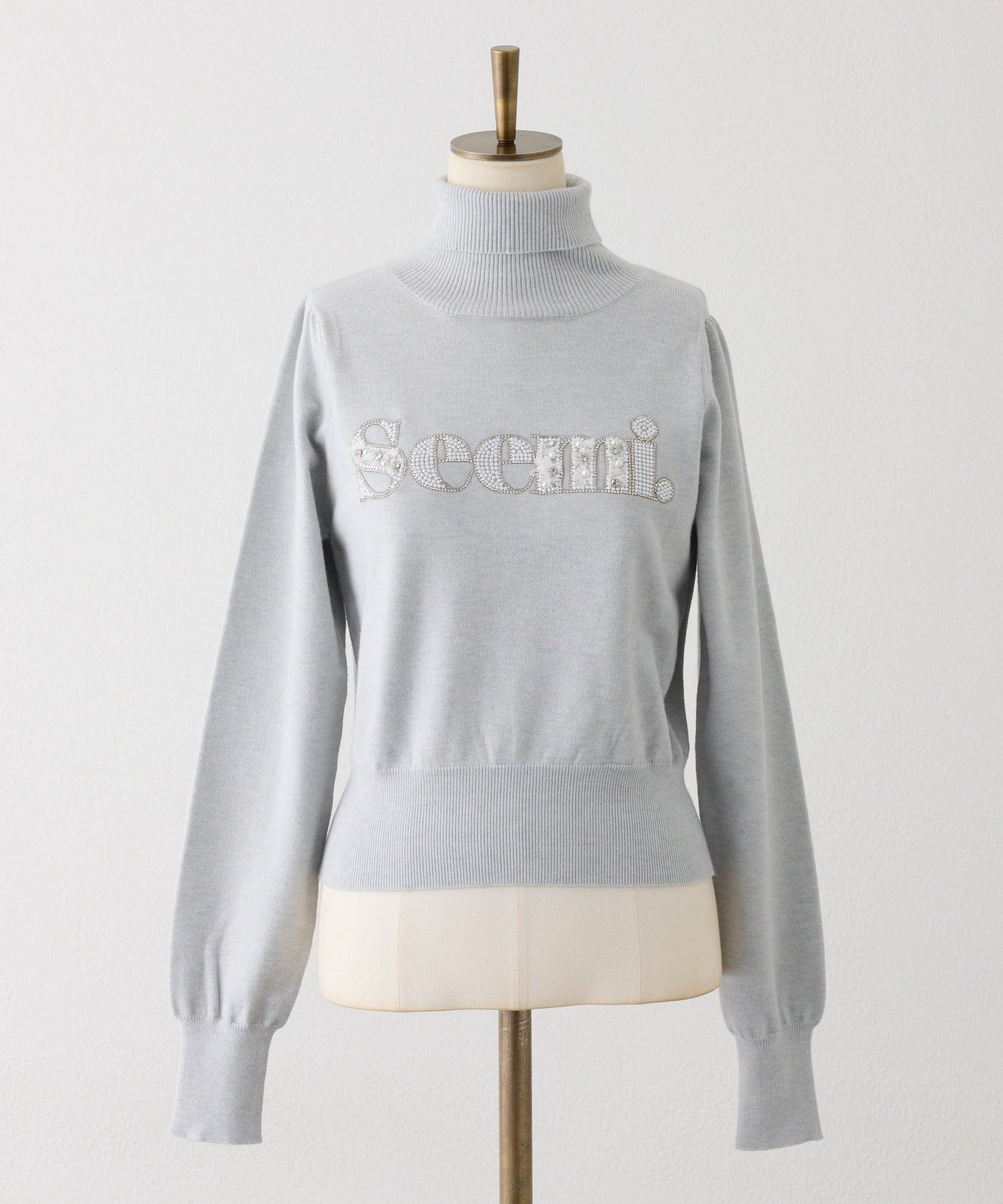 Seemi.by NICE CLAUP(シーミーバイナイスクラップ) ハイネックビジューロゴニット