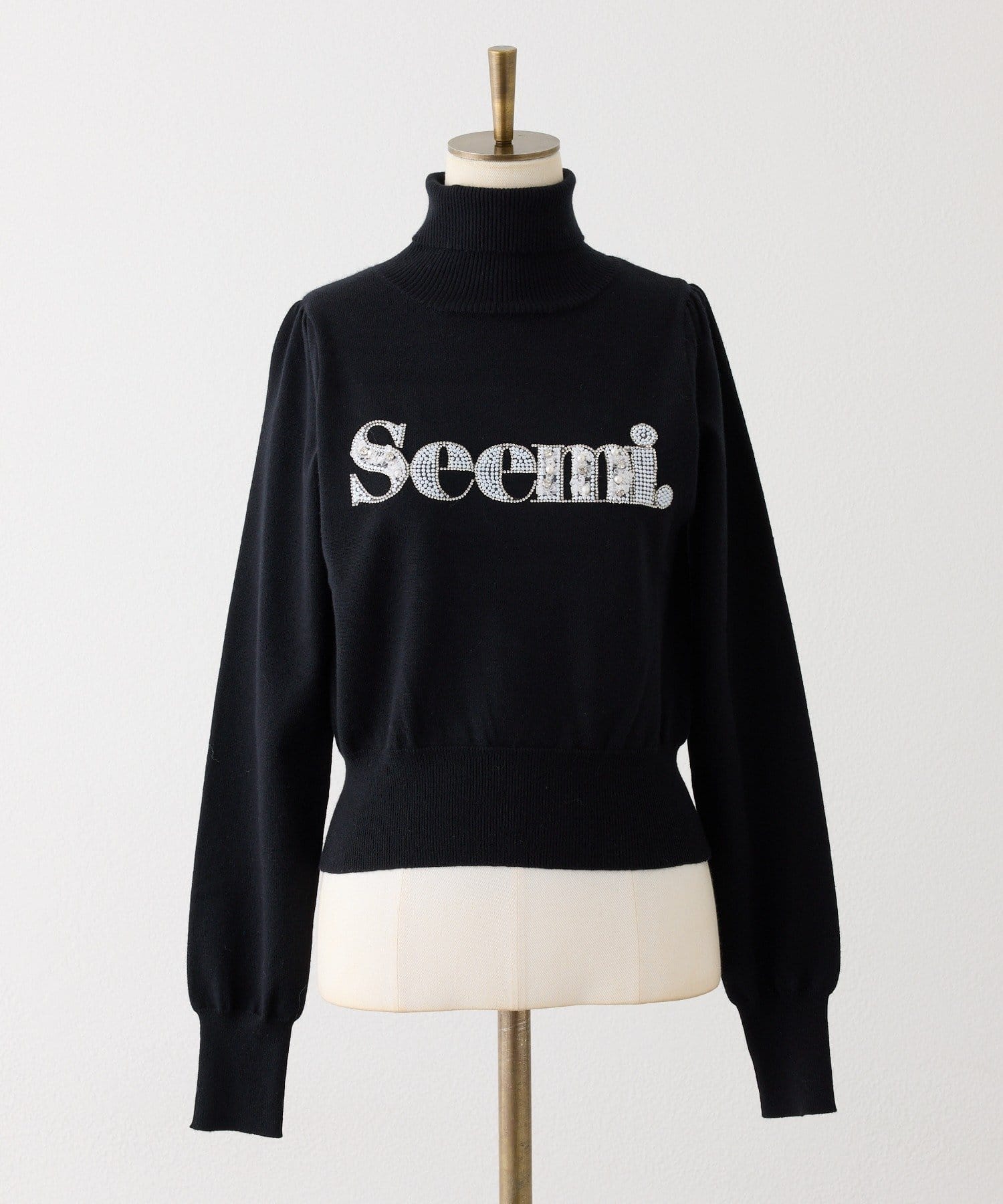 Seemi.by NICE CLAUP(シーミーバイナイスクラップ) ハイネックビジューロゴニット